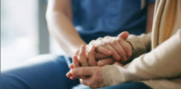 Nurse holding patients hand